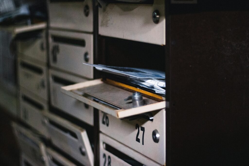 Close-up of an open mailbox in a residential building with visible mail, showcasing selective focus.