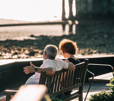 Older couple sitting on a bench enjoying a seaside sunset in Perillo, GA, Spain. aposentar