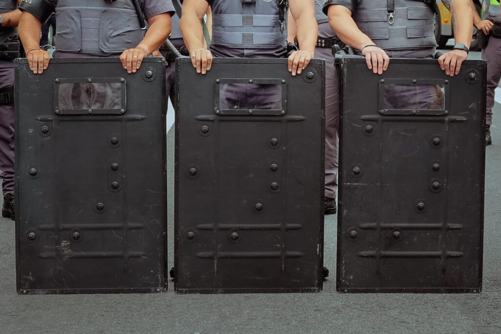 Riot police officers holding protective shields, showcasing security and public order enforcement.